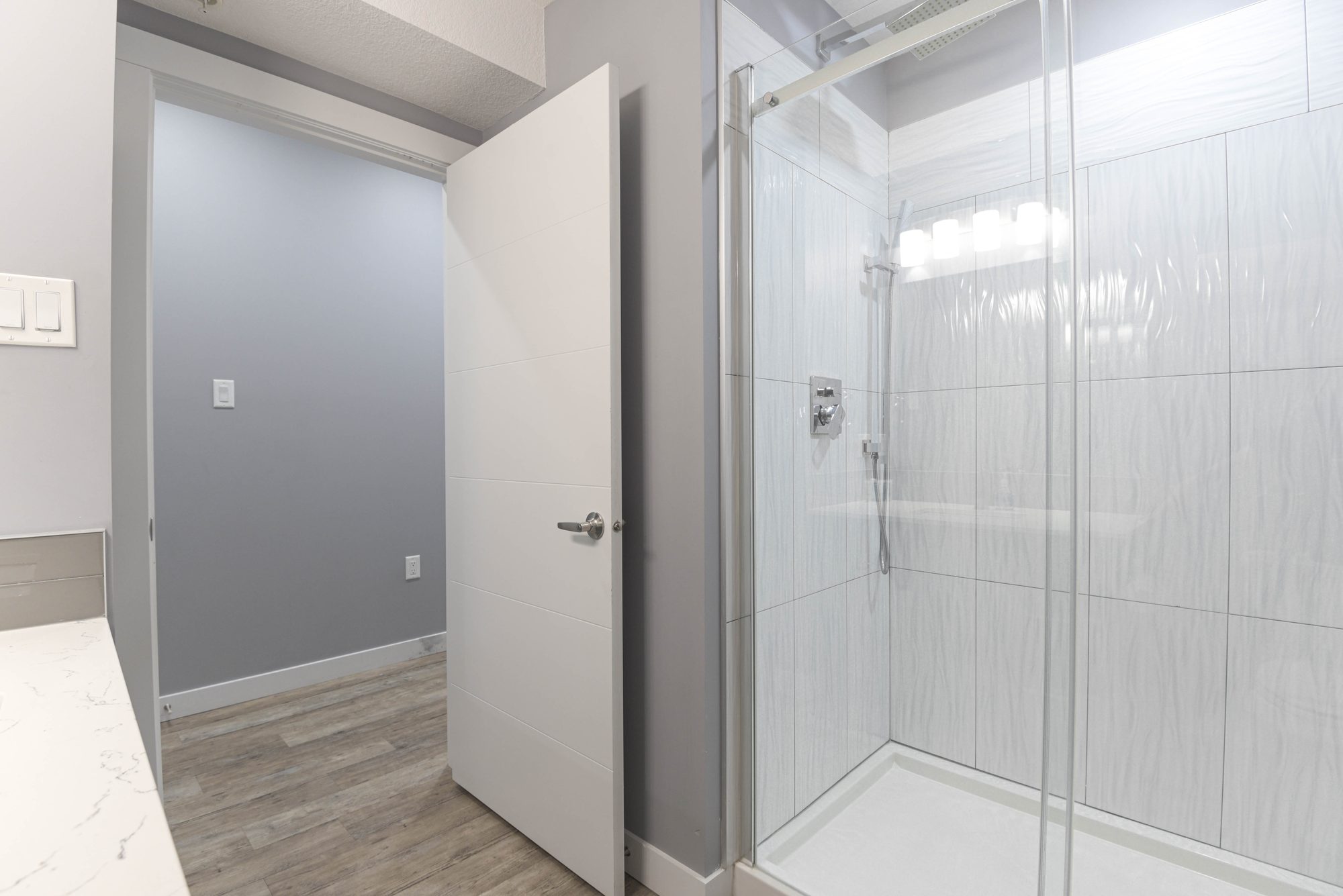 Hallway view into the bathroom with glass walk-in shower