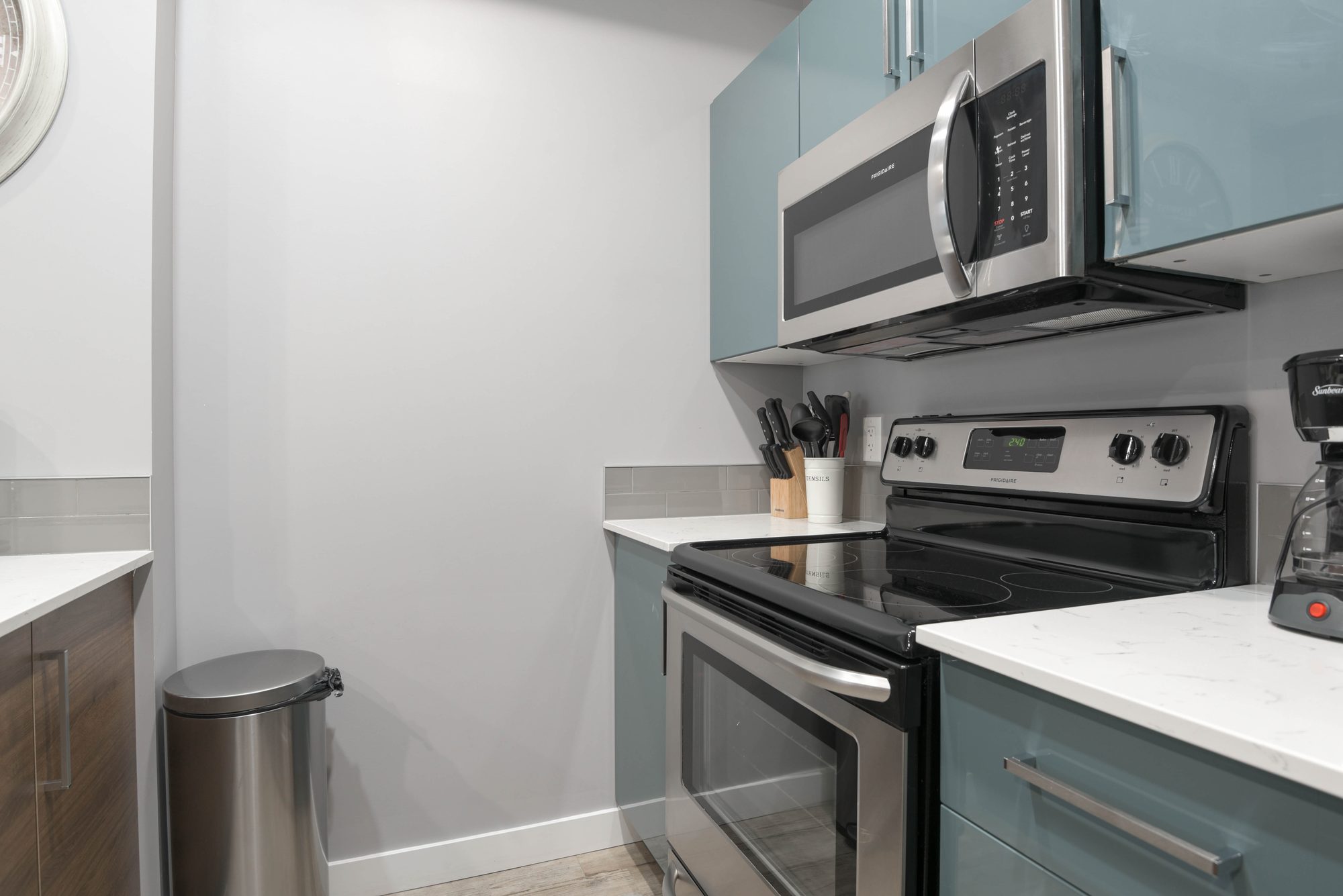 One bedroom kitchen with stainless steel range, microwave, and coffee station