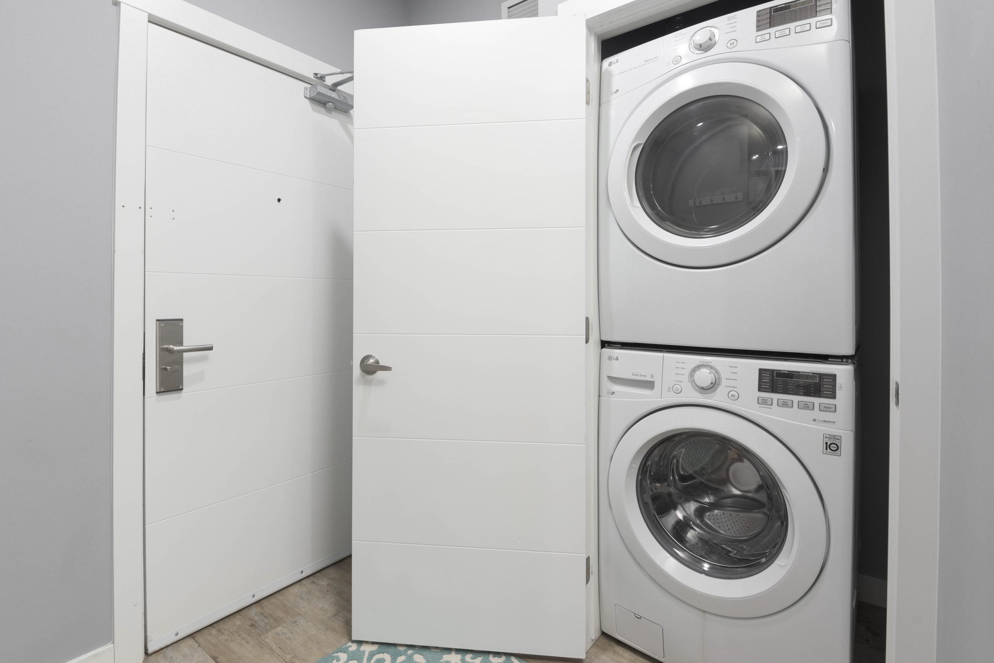 Stacked in-suite washer and dryer behind the suite entry door